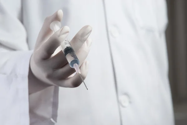 Врач или медсестра держат шприц, готовый к инъекции — стоковое фото