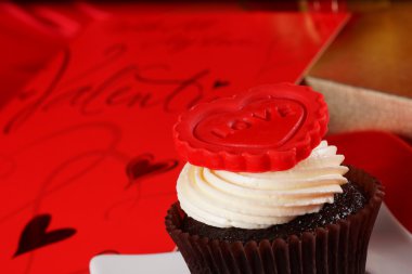 Cupcake üstte ve hediyeler kırmızı saten kutularındaki kırmızı bir kalp ile 