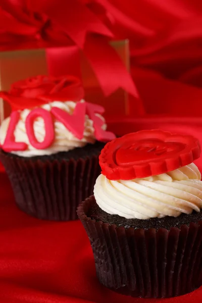 Luxe cupcake met geschenken vakken op rode satijnen achtergrond — Stockfoto