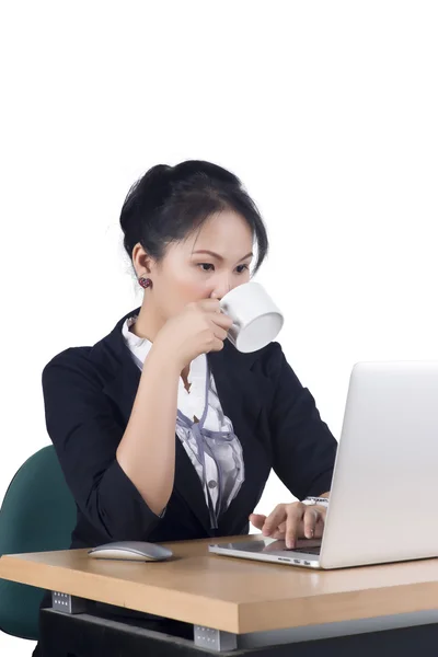 Jonge zakenvrouw geeuwen op haar bureau met een kopje koffie — Stockfoto