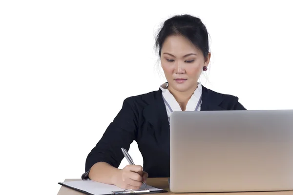 Porträtt av affärskvinna med laptop skriver på ett dokument på h — Stockfoto