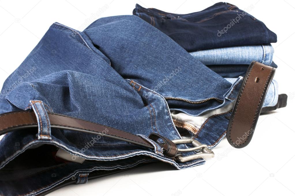 Stack of various shades of blue jeans with brown belts