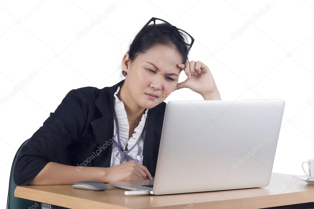 Bored business woman working on laptop looking very boring at th