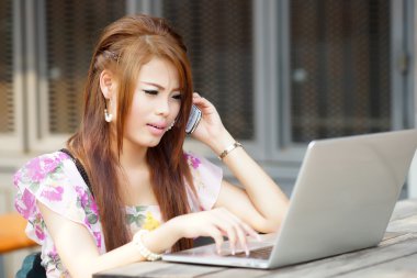 Laptopunu açık, üzerinde çalışan genç çekici iş kadın