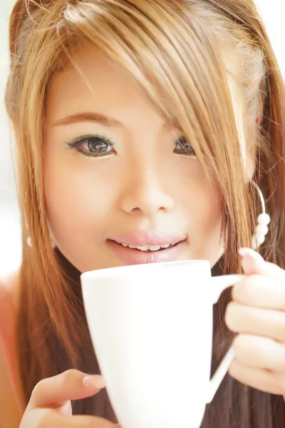 Closeup beautiful woman sitting in cafe holding and drinking cof — Stock Photo, Image