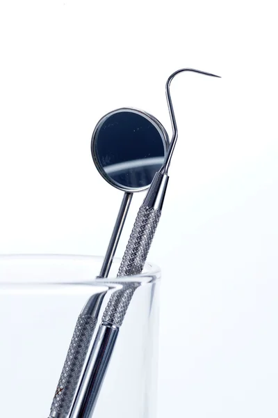 Dvě stomatologické nástroje ve skle: zubní zrcátko a sondy — Stock fotografie