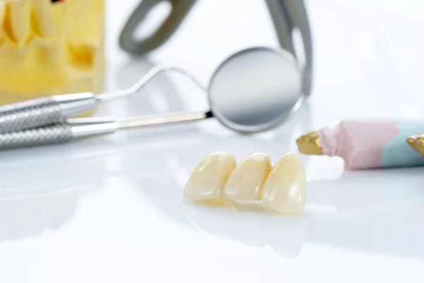 Macro of prosthetic teeth with dental tools — Stock Photo, Image