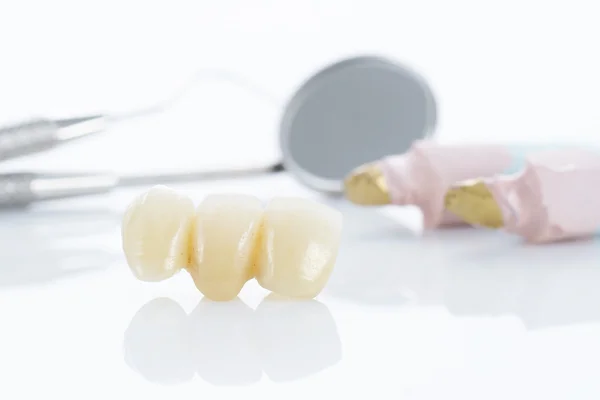 Macro of prosthetic teeth with dental tools — Stock Photo, Image