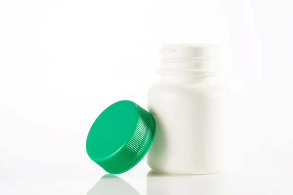 Frasco de medicamento blanco vacío de pie con la tapa al lado —  Fotos de Stock