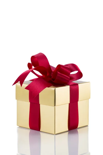 Beautiful gold present box with red bow and ribbons — Stock Photo, Image