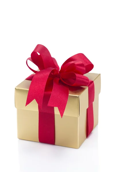 Красивая золотая коробка с красным луком и лентами — стоковое фото
