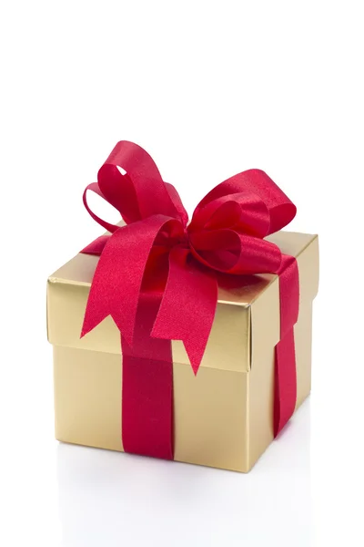 Beautiful gold present box with red bow and ribbons Stock Image