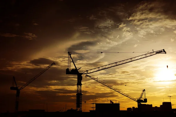 Paesaggio industriale con sagome di gru sul tramonto ba — Foto Stock