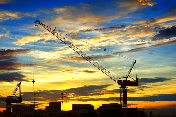 Paesaggio industriale con sagome di gru sul tramonto ba — Foto Stock