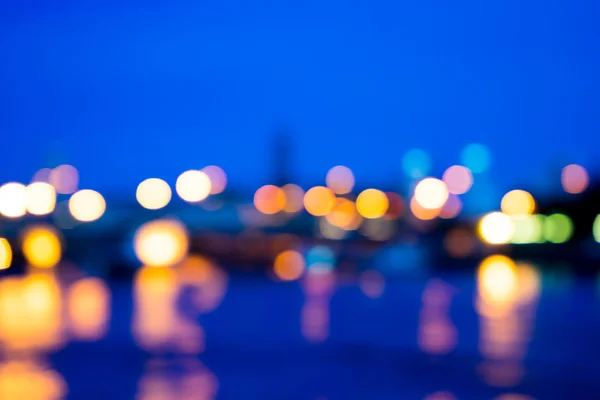 Vista de desenfoque de luz nocturna con luz de reflexión en el agua — Foto de Stock