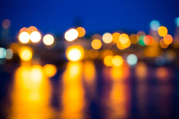 Vista de desenfoque de luz nocturna con luz de reflexión en el agua — Foto de Stock