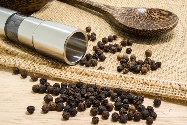 Pepper grinder and black peppercorn — Stock Photo, Image
