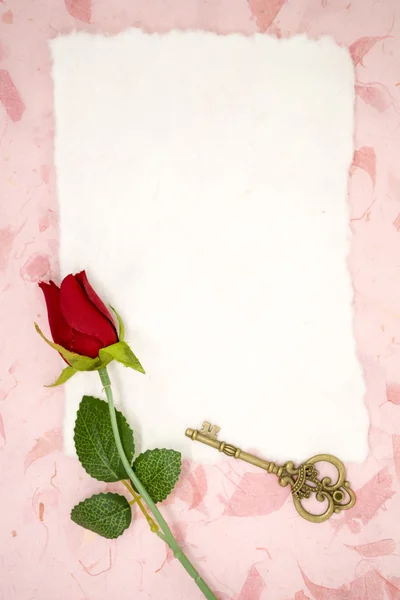 Papel em branco com rosa vermelha e chave velha — Fotografia de Stock