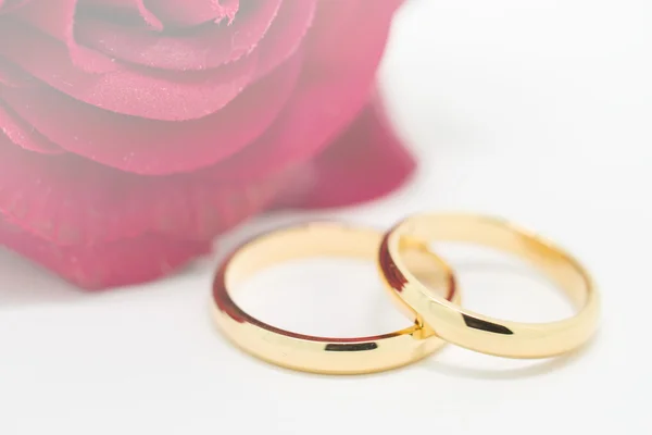 결혼 반지와 백색 배경에 인공 로즈 — 스톡 사진