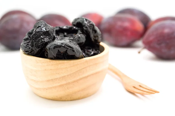 Deliciosas ciruelas pasas en tazón de madera y ciruelas frescas — Foto de Stock