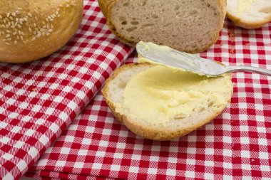 Tereyağı ile yuvarlak ekmek dilimlenmiş