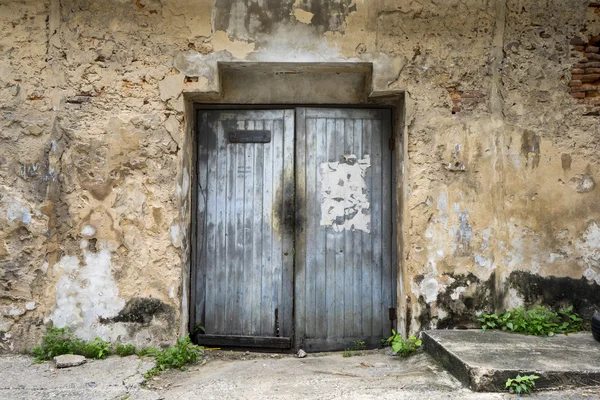 Porta de madeira na parede velha na fachada abandonada — Fotografia de Stock