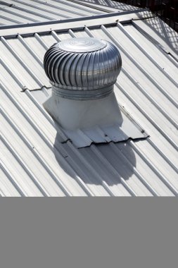 Stainless steel exhaust fan on factory roof clipart