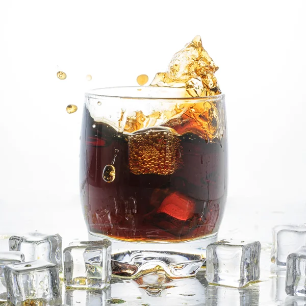 Ice cube droped i cola glas och cola stänk — Stockfoto