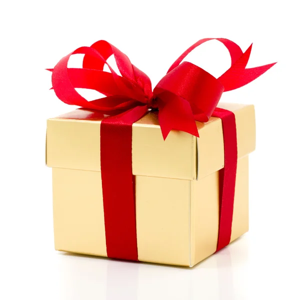 Beautiful gold present box with red bow and ribbons — Stock Photo, Image