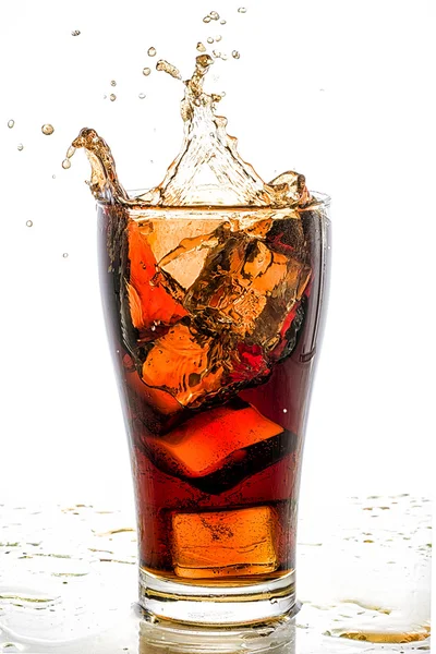 Ice cube droped v cola sklo a cola šplouchání — Stock fotografie