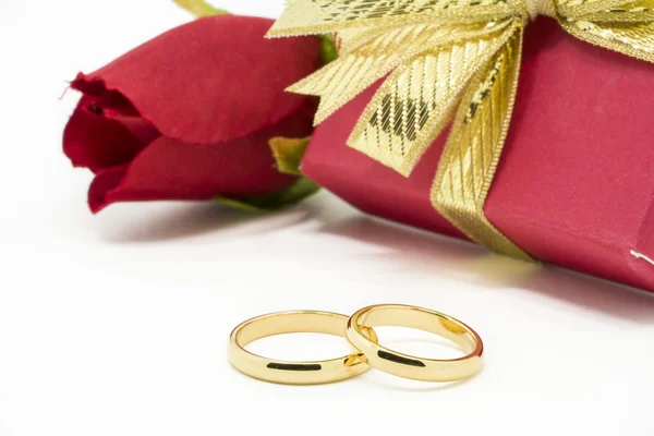 Wedding rings and artificial rose on white background — Stock Photo, Image