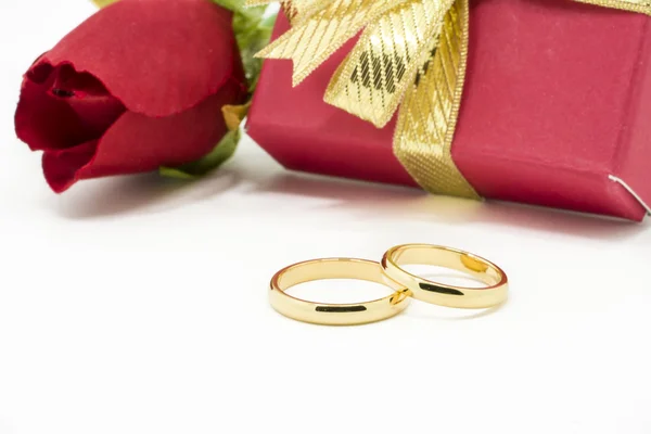 Wedding rings and artificial rose on white background — Stock Photo, Image