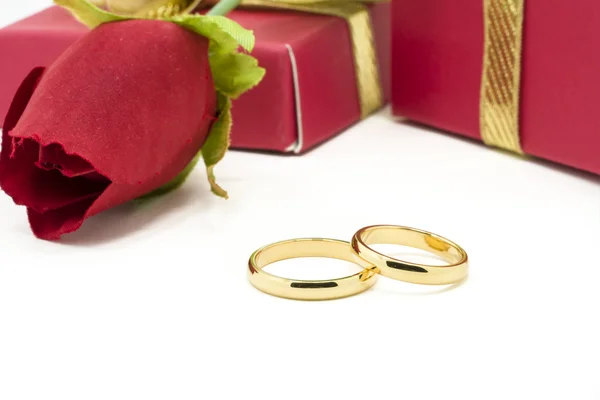 Wedding rings and artificial rose on white background — Stock Photo, Image