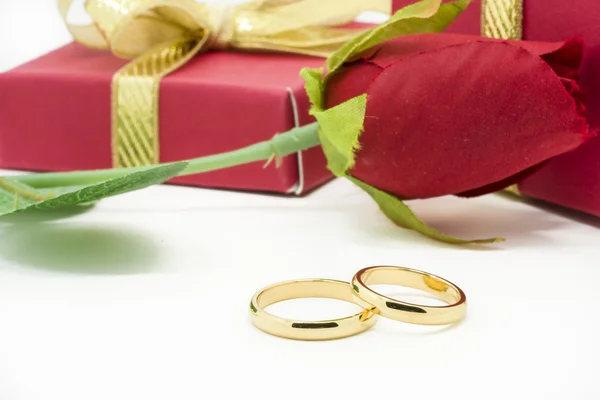 Wedding rings and artificial rose on white background — Stock Photo, Image