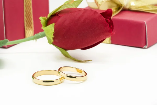 Wedding rings and artificial rose on white background — Stock Photo, Image