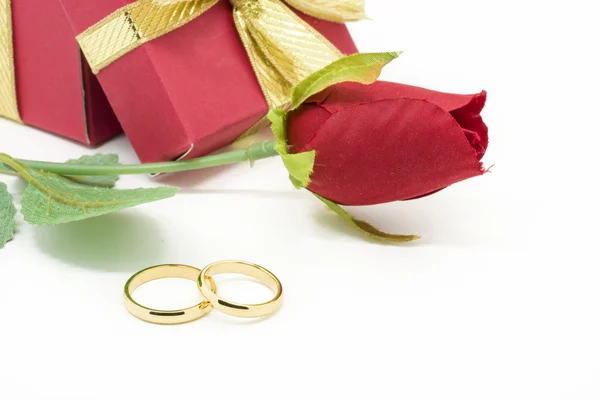 Wedding rings and artificial rose on white background — Stock Photo, Image