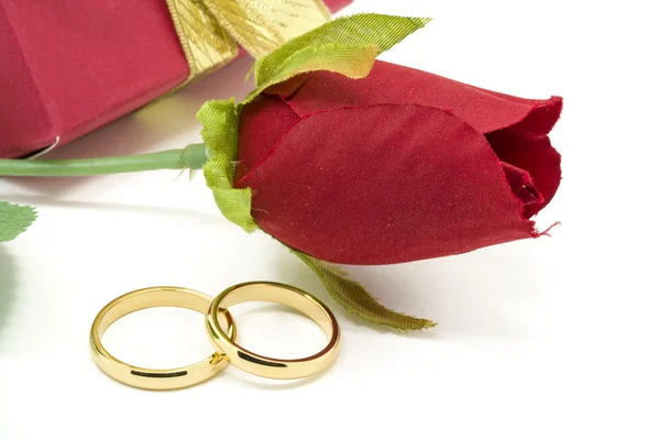 Wedding rings and artificial rose on white background — Stock Photo, Image