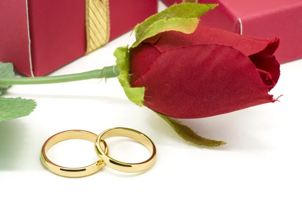 Wedding rings and artificial rose on white background — Stock Photo, Image