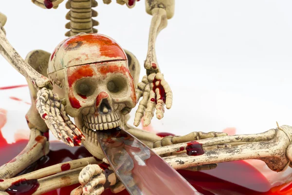 Nature morte squelette dans le sang avec couteau sur fond blanc — Photo