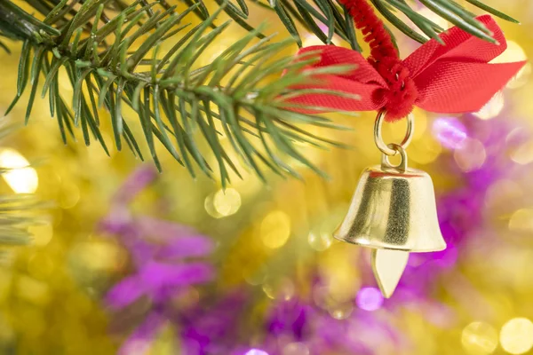 Weihnachtsglockenschmuck hängt mit gelbem Bokeh am Ast — Stockfoto