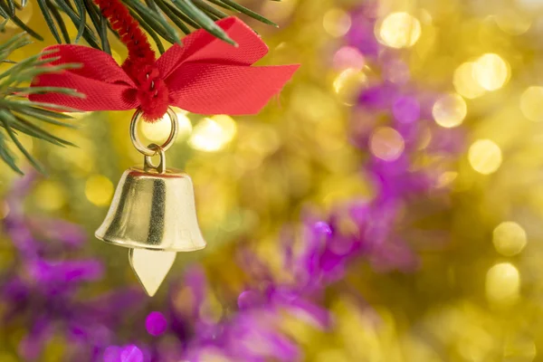 Weihnachtsglockenschmuck hängt mit gelbem Bokeh am Ast — Stockfoto
