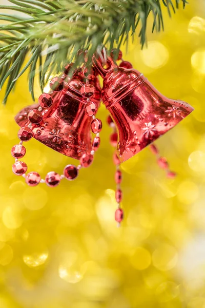 Christmas bell ornament hang on tree branch with yellow bokeh ba