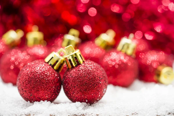 Red Christmas balls on snow against red bokeh background Stock Picture