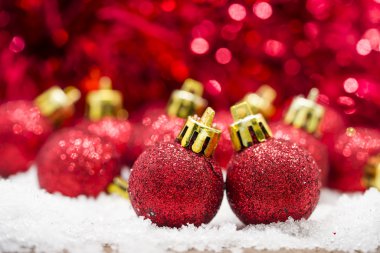 Kar kırmızı bokeh arka plan üzerinde kırmızı Noel topları