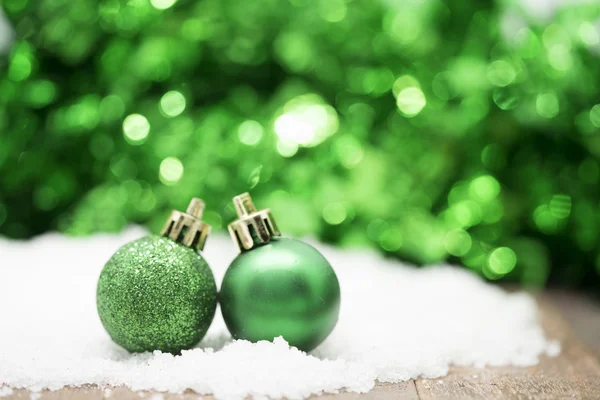 Verde bolas de Navidad en la nieve contra fondo bokeh verde —  Fotos de Stock