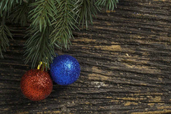 Stillleben von Weihnachtsschmuck und Baumzweig auf Holzbrett — Stockfoto