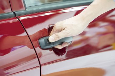 Eller arabanın kapısını açarak yakın çekim.