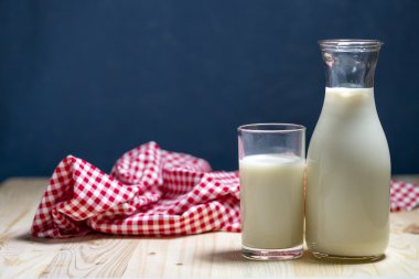 Süt şişesi ve süt cam ahşap masanın üstüne koy.