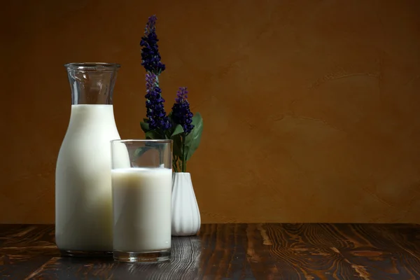 Botella de leche y vaso de leche poner en la mesa de madera . — Foto de Stock