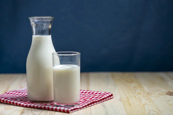 Süt şişesi ve süt cam ahşap masanın üstüne koy. — Stok fotoğraf